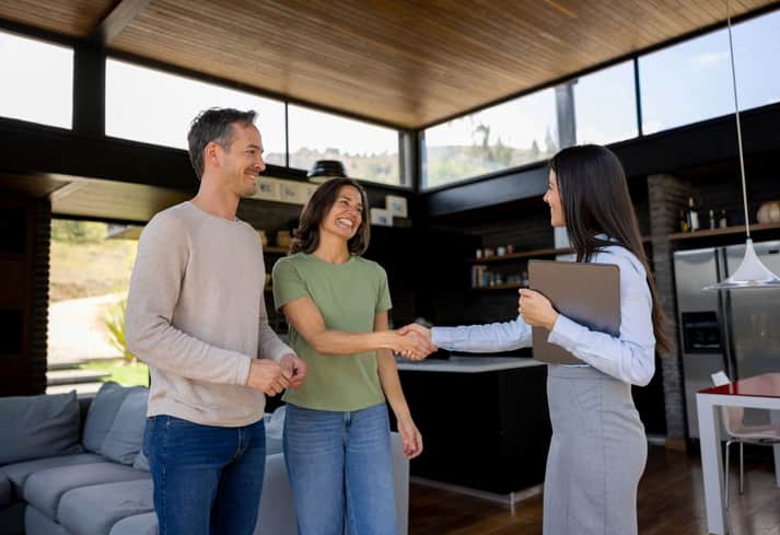 Real estate agent handshaking with a couple of customers