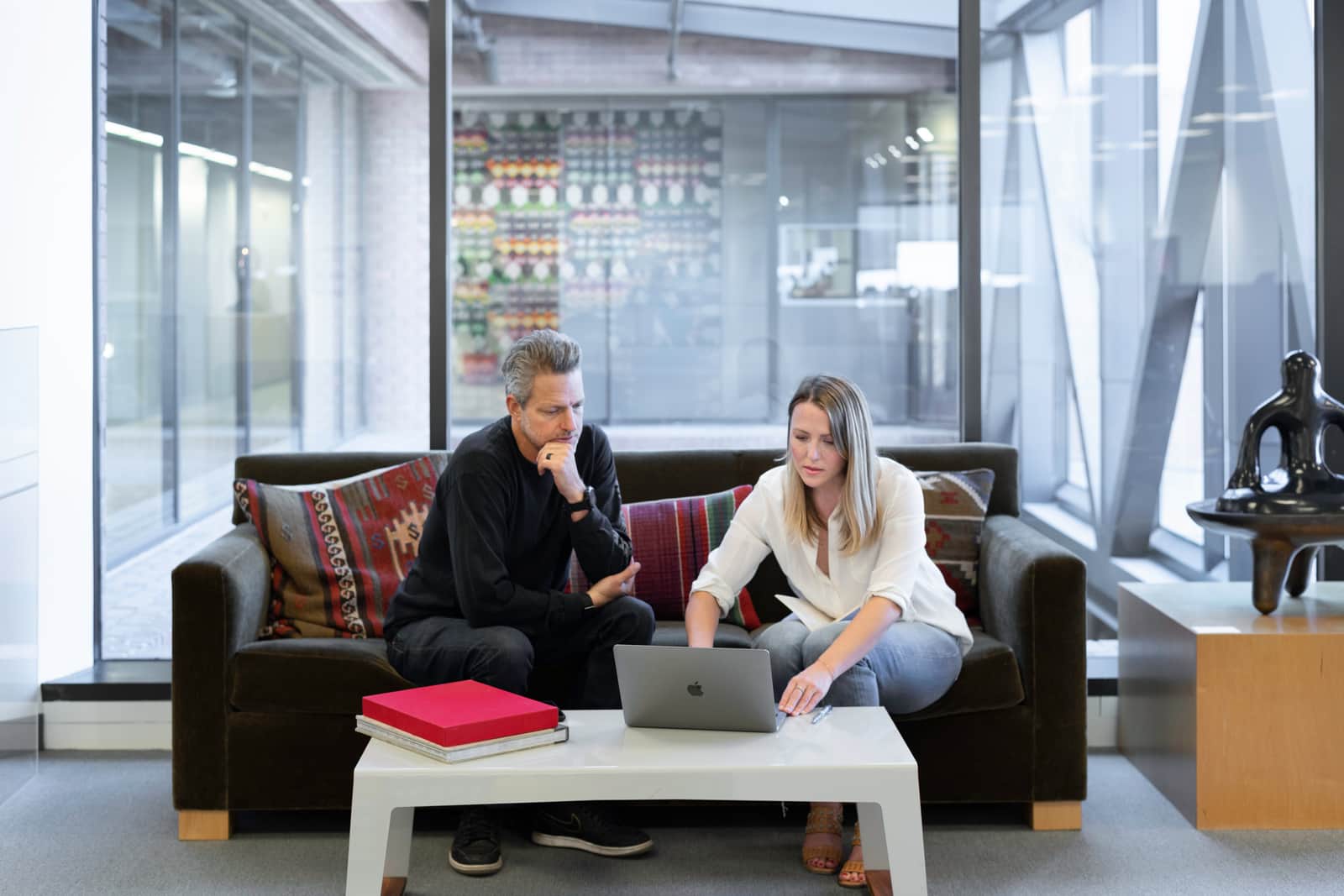man and woman laptop office couch